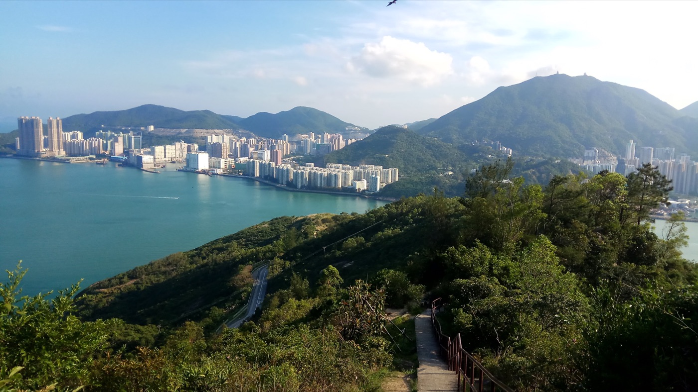 Hiking trail overlooking the Hong Kong skyline and harbour from a mountain ridge